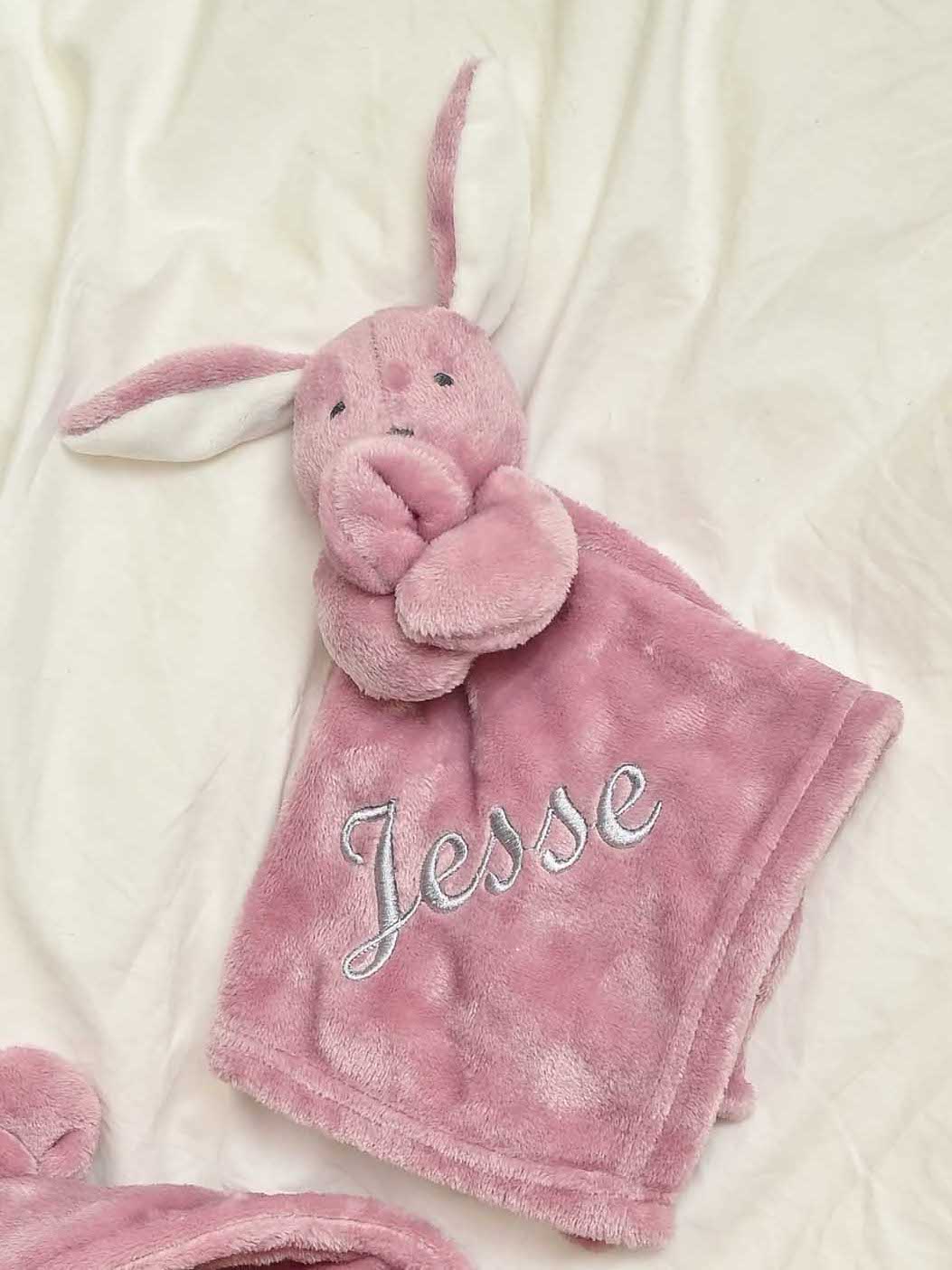 our Babies personalised bunny comforter in Dusky Pink is crafted from super soft plush material, this comforter will keep your baby snug and content. Complete with your babies name personalised/embroidered to the front.