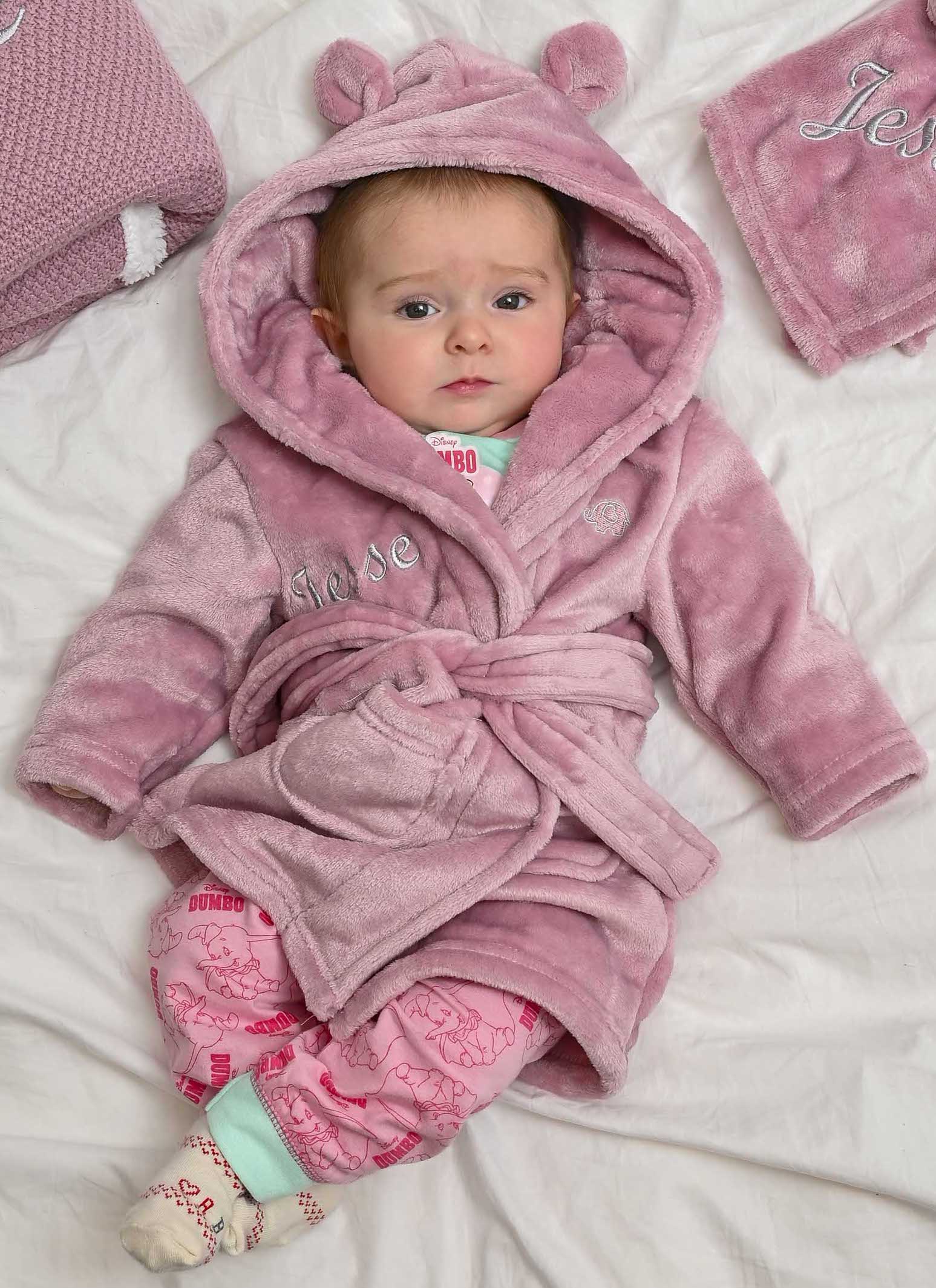  Babies personalised Dusky Pink hooded dressing gown. Made from super soft material, it features an elephant embroidery to the chest as well as detailing pom pom ears and a hood. Make it extra special by adding a personalised touch.